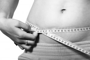 A belly being measure with measuring tape