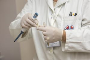 Laboratory Scientist in white coat with rubber gloves