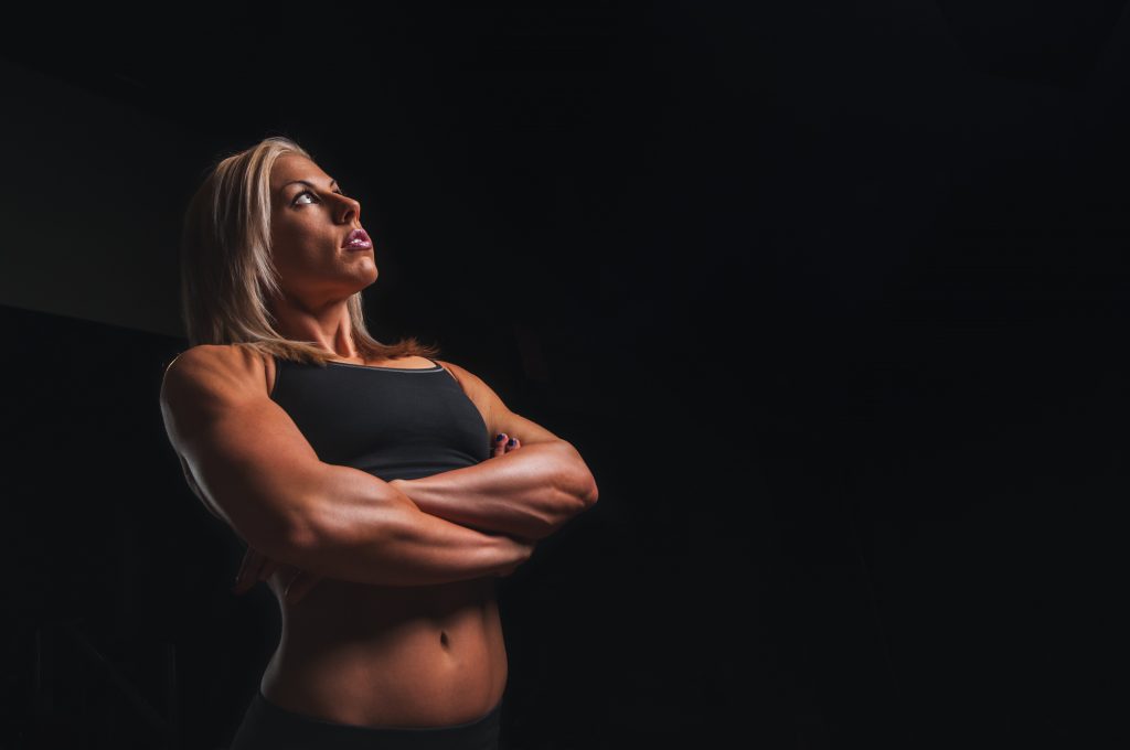 muscular woman contemplating with arms crossed