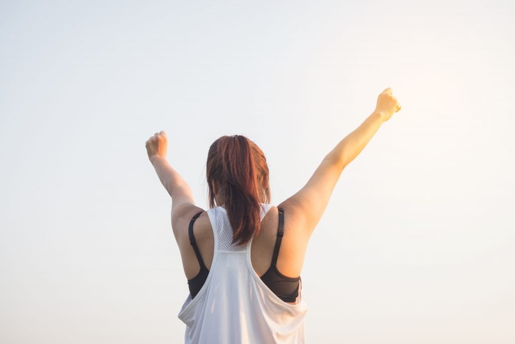 woman with arms stretched out in achievement